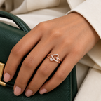 Adeline rose gold plated double-band heart ring worn on a model's hand beside a cream tailored sleeve