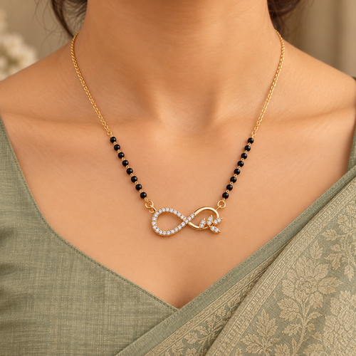 Ananta Mangalsutra infinity and leaf pendant worn with a modest sage silk saree in close-up