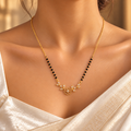 Vallari gold-plated mangalsutra worn with an ivory silk saree, close-up