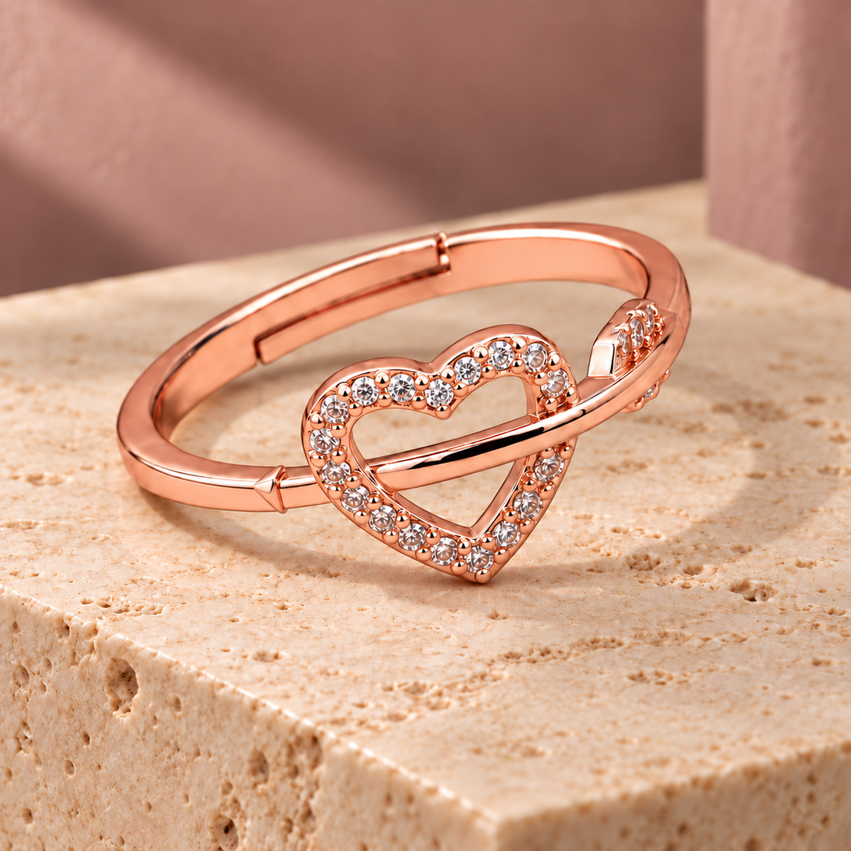 Evermore rose gold plated open-heart ring with smooth crossover band on ivory travertine