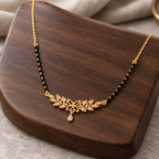 Madhavi floral mangalsutra on dark walnut wood, photographed from an oblique angle