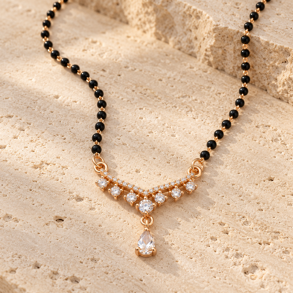 Saanvika Mangalsutra compact seven-stone pendant and hanging pear photographed at an angle on travertine