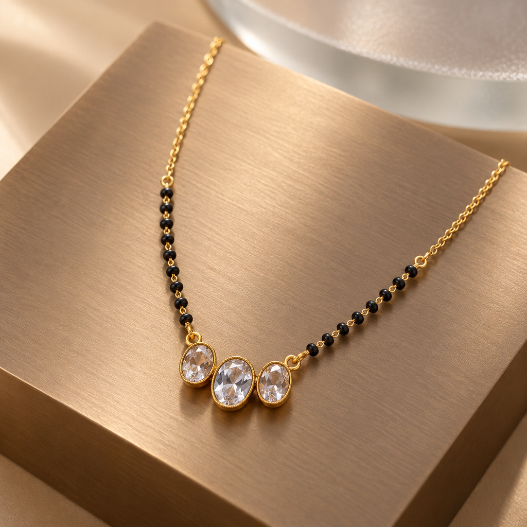 Vaidehi Mangalsutra with three pale oval centres photographed at an angle on brushed bronze