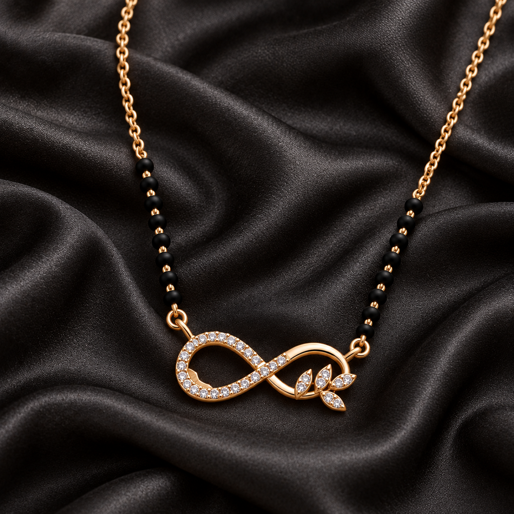 Close overhead detail of Ananta Mangalsutra infinity and leafy pendant on charcoal silk