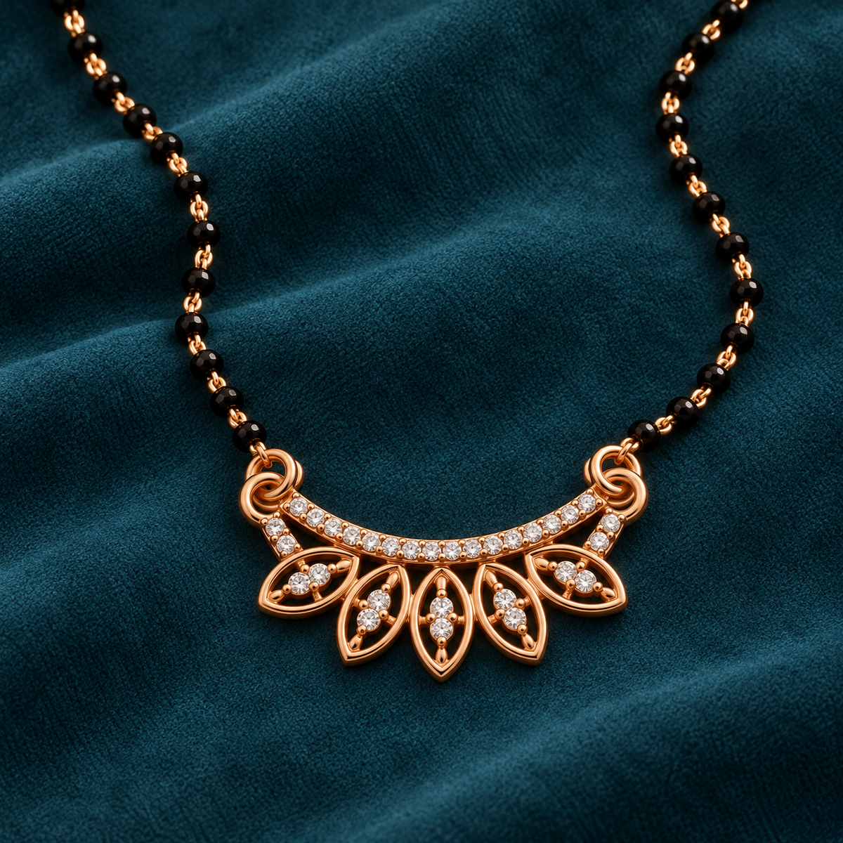 Close detail of Anvaya Mangalsutra five open marquise frames and clear accents on deep petrol suede