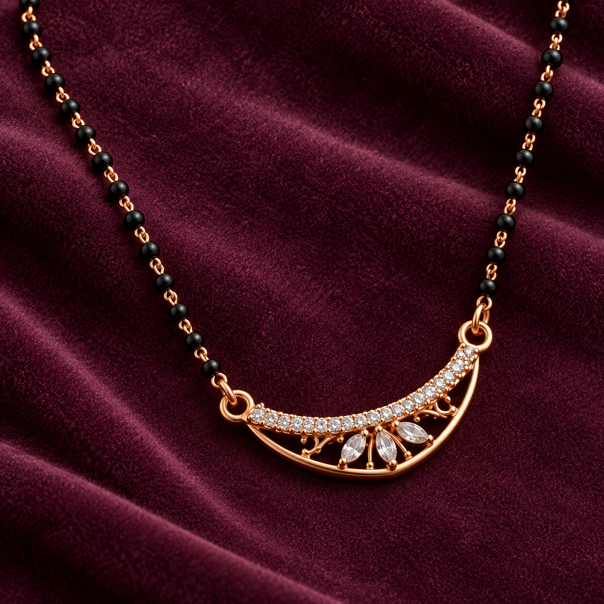 Chandralekha Mangalsutra crescent and three clear petal-shaped stones on plum velvet