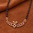 Overhead detail of Hansika Mangalsutra paired scrolls and clear accent fringe on warm russet suede