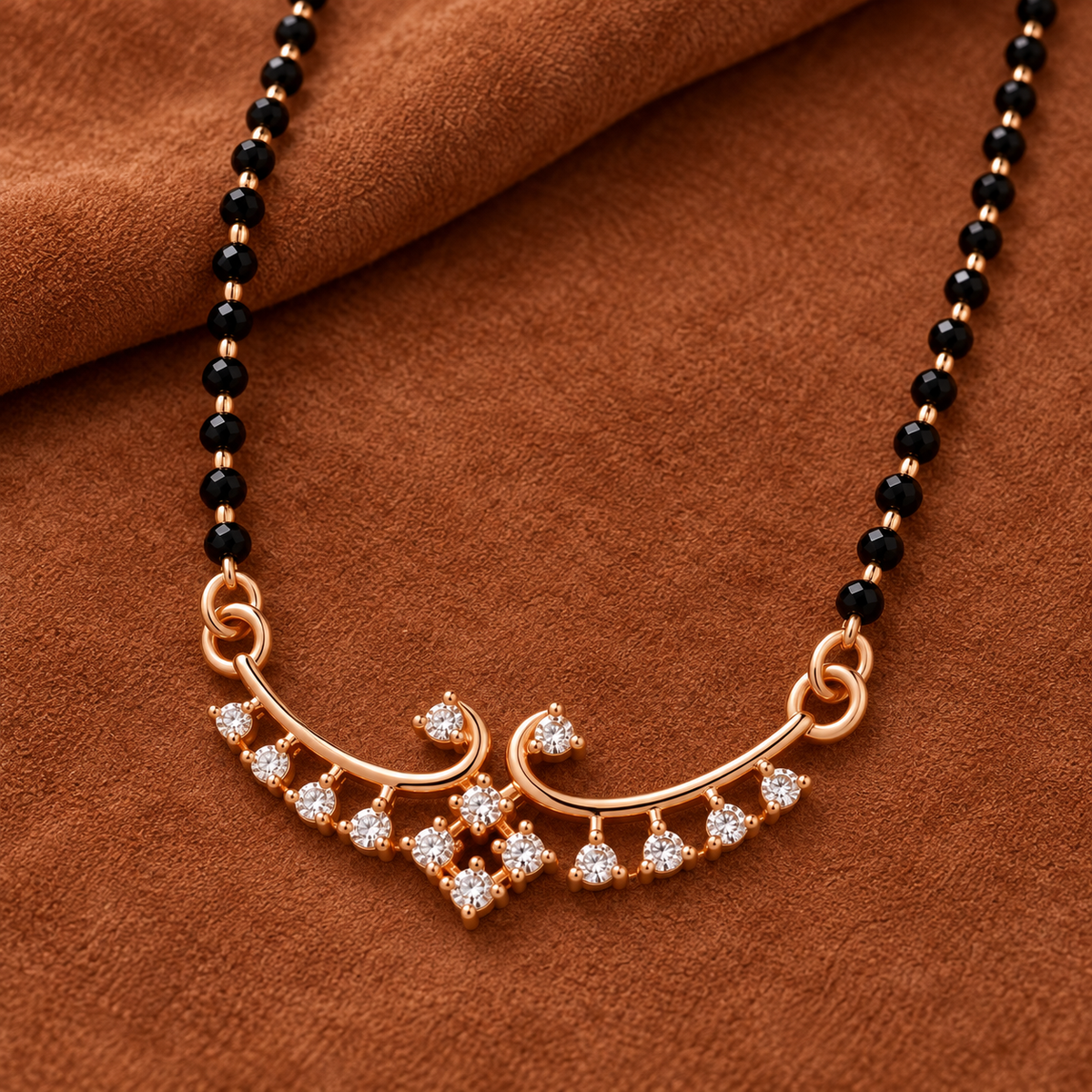 Overhead detail of Hansika Mangalsutra paired scrolls and clear accent fringe on warm russet suede