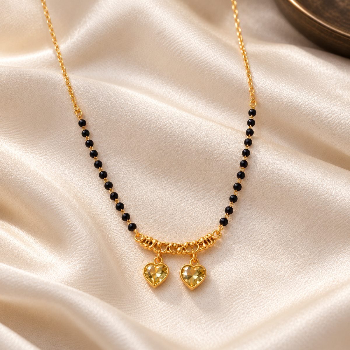 Overhead detail of Kanakpriya twin-heart mangalsutra on ivory silk
