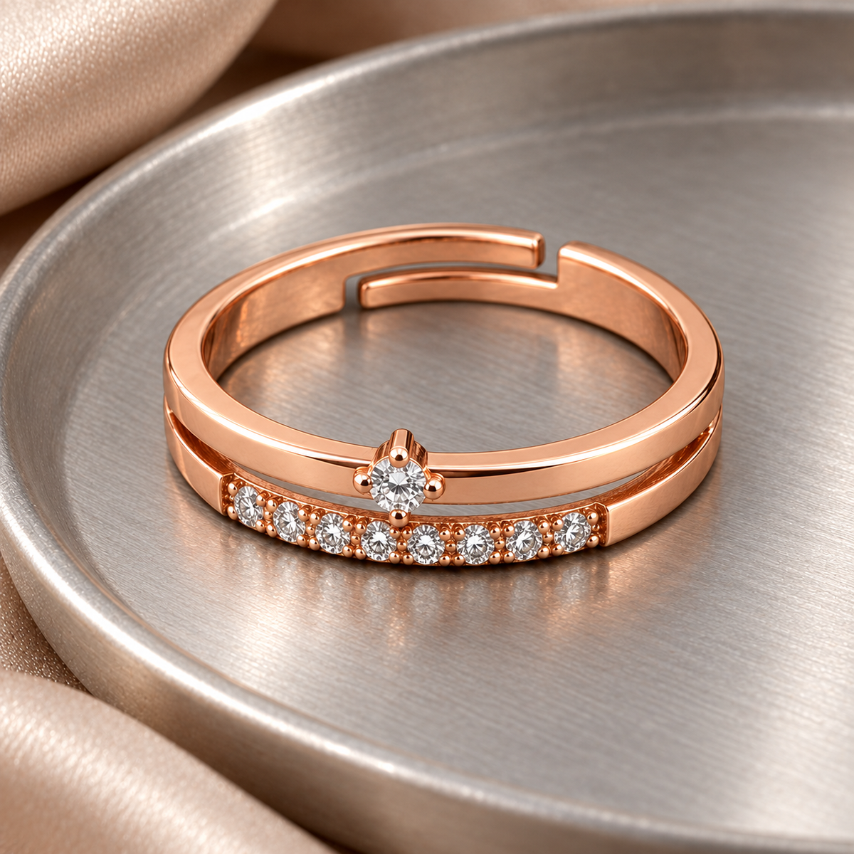 Serenity ring from a higher angle on brushed metal, showing the centred upper stone and lower accent row