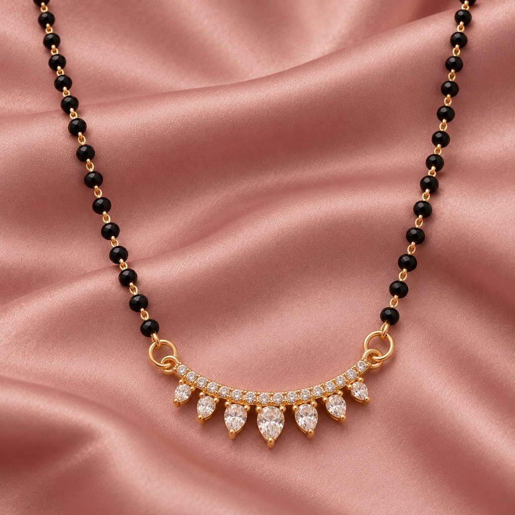 Overhead detail of Sitara Mangalsutra seven graduated clear teardrops on dusty-rose satin