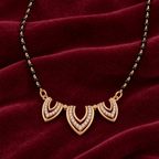 Close detail of Trishika Mangalsutra three openwork motifs and clear accents on burgundy velvet