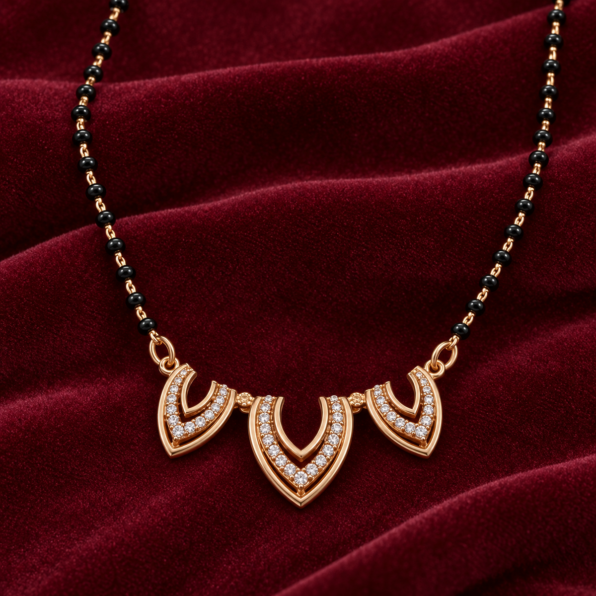 Close detail of Trishika Mangalsutra three openwork motifs and clear accents on burgundy velvet