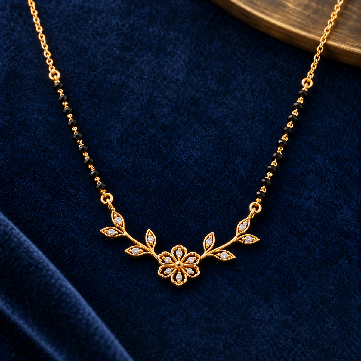 Close detail of Vallari floral mangalsutra on midnight-blue velvet