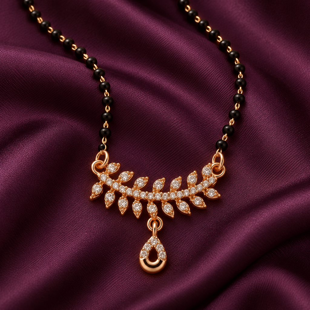 Close detail of Vanalika Mangalsutra leaf accents and open teardrop charm on aubergine silk