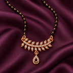 Close detail of Vanalika Mangalsutra leaf accents and open teardrop charm on aubergine silk