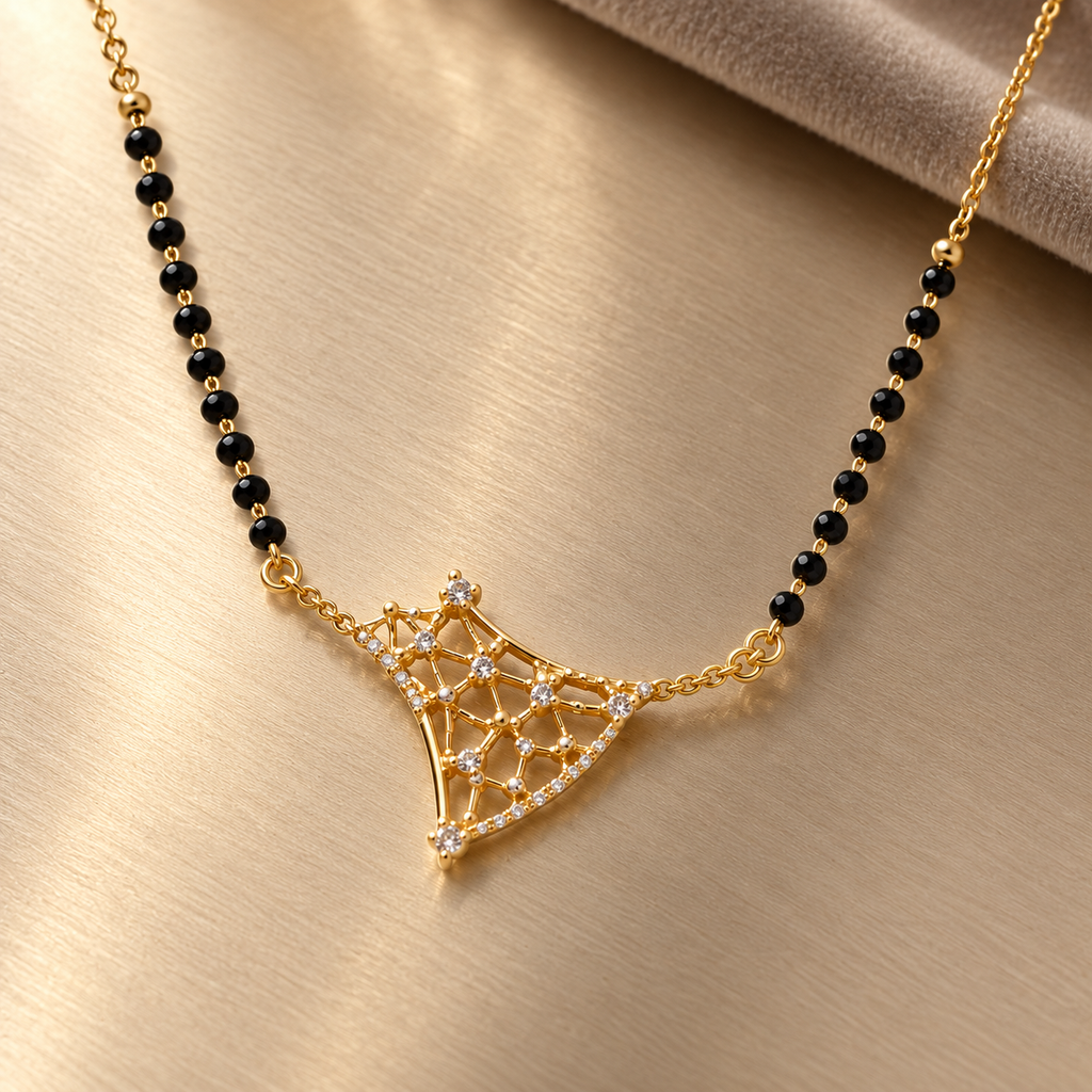 Overhead detail of Varnika openwork mangalsutra on brushed champagne metal
