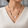 Bellora Mangalsutra worn with an ivory woven V-neck dress, showing the pendant and black bead chain.