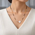 Celiane Mangalsutra worn with an ivory woven V-neck dress, showing the pendant and black bead chain.