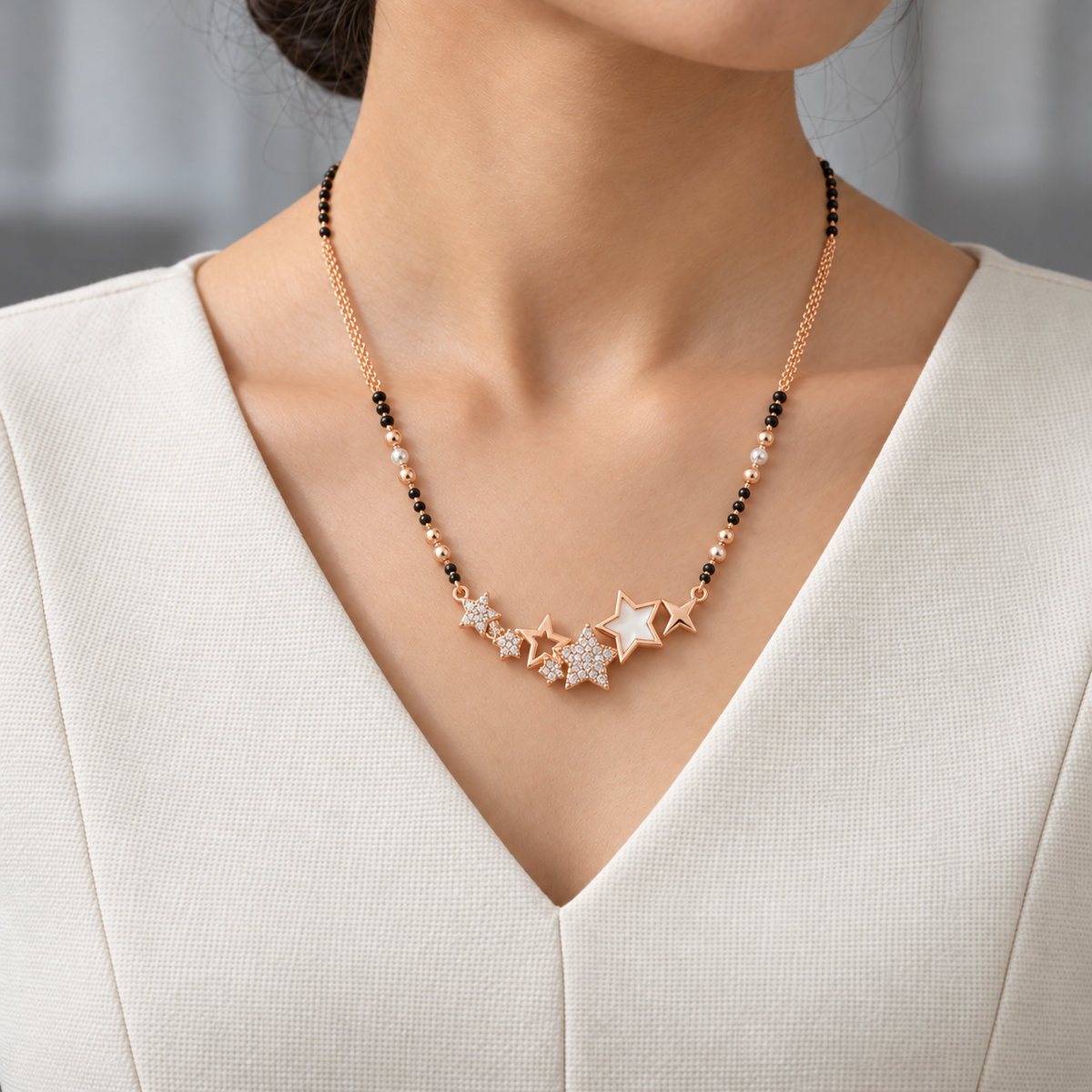 Estoria Mangalsutra worn with an ivory woven V-neck dress, showing the pendant and black bead chain.