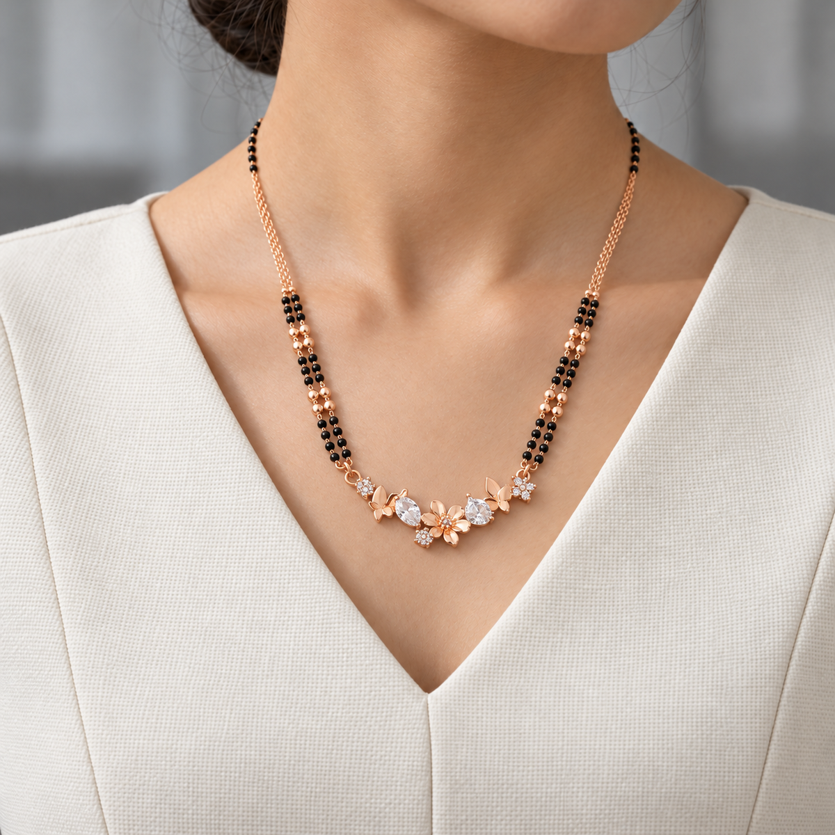Fiora Mangalsutra worn with an ivory woven V-neck dress, showing the pendant and black bead chain.