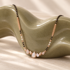 White pear-row mangalsutra on an olive ceramic sculpture