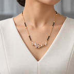 Lisette Mangalsutra worn with an ivory woven V-neck dress, showing the pendant and black bead chain.