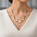 Lorelle Mangalsutra worn with an ivory woven V-neck dress, showing the pendant and black bead chain.
