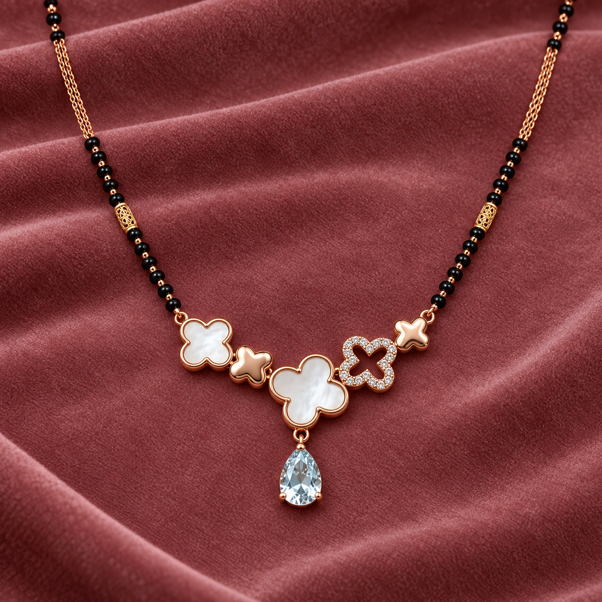 Maelle Mangalsutra — clover pendant detail on dusty-rose velvet