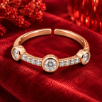 Trinity Ring rose gold plated ring from high angle on crimson velvet with red glass bokeh