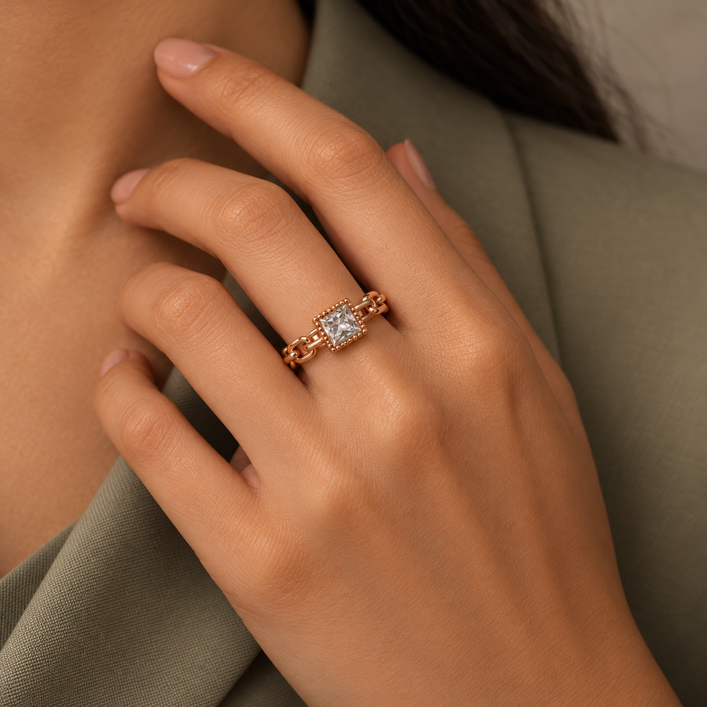 Camille Ring in rose gold, worn snugly on a model's hand beside elegant tailored sage/taupe professional dress with modest covered chest