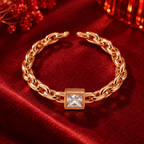 Camille Ring in rose gold, from a high angle on burgundy satin with warm festive bokeh