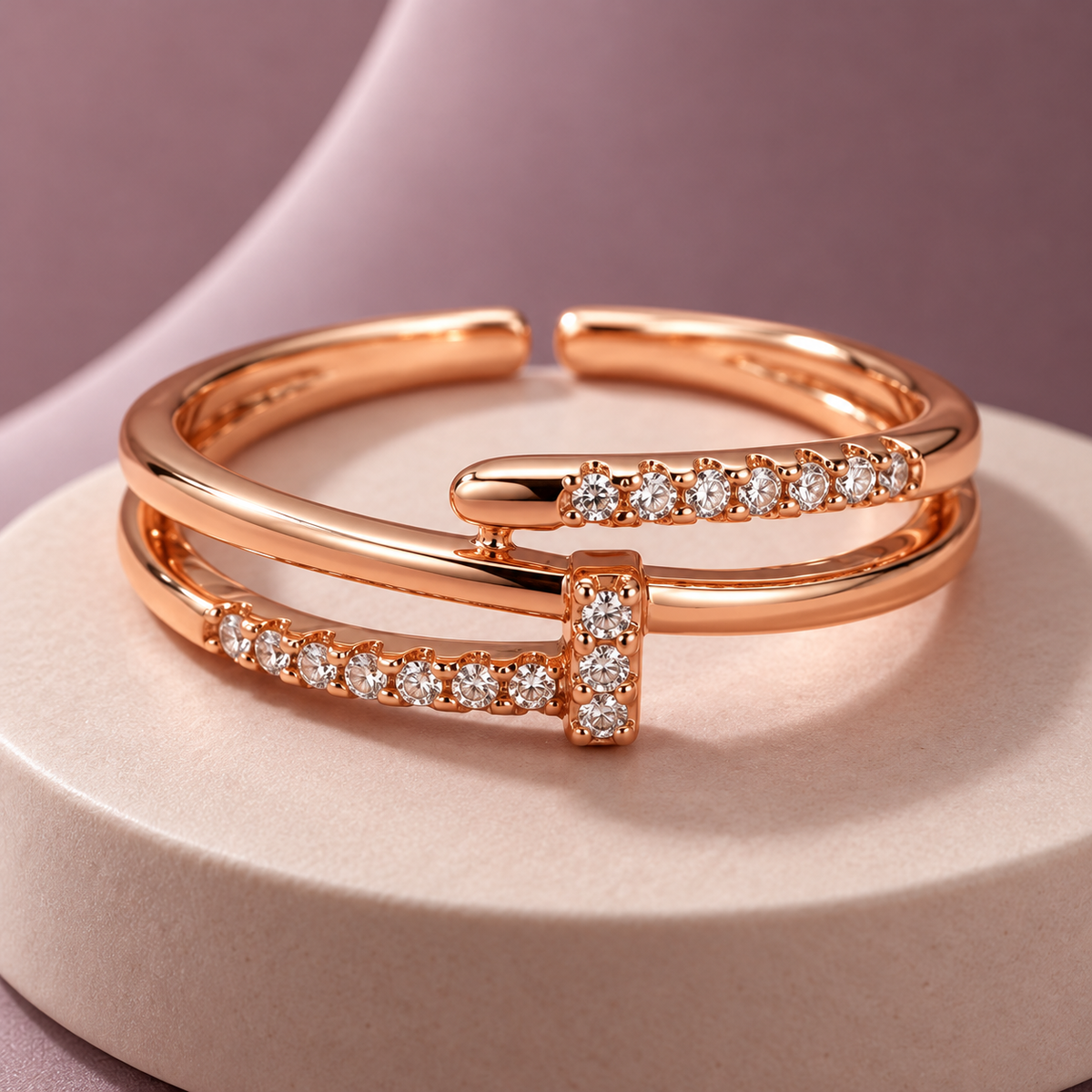 Lucienne Ring in rose gold, on a pale round plinth against a dusty mauve backdrop