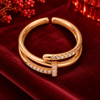 Lucienne Ring in rose gold, from a high angle on burgundy satin with warm festive bokeh