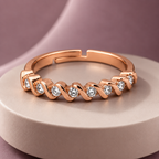 Ophelia Ring in rose gold, on a pale round plinth against a dusty mauve backdrop