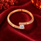 Clarisse Ring in rose gold, from a high angle on burgundy satin with warm festive bokeh