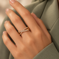 Evangeline rose gold plated crossover ring — model hand in premium editorial lighting
