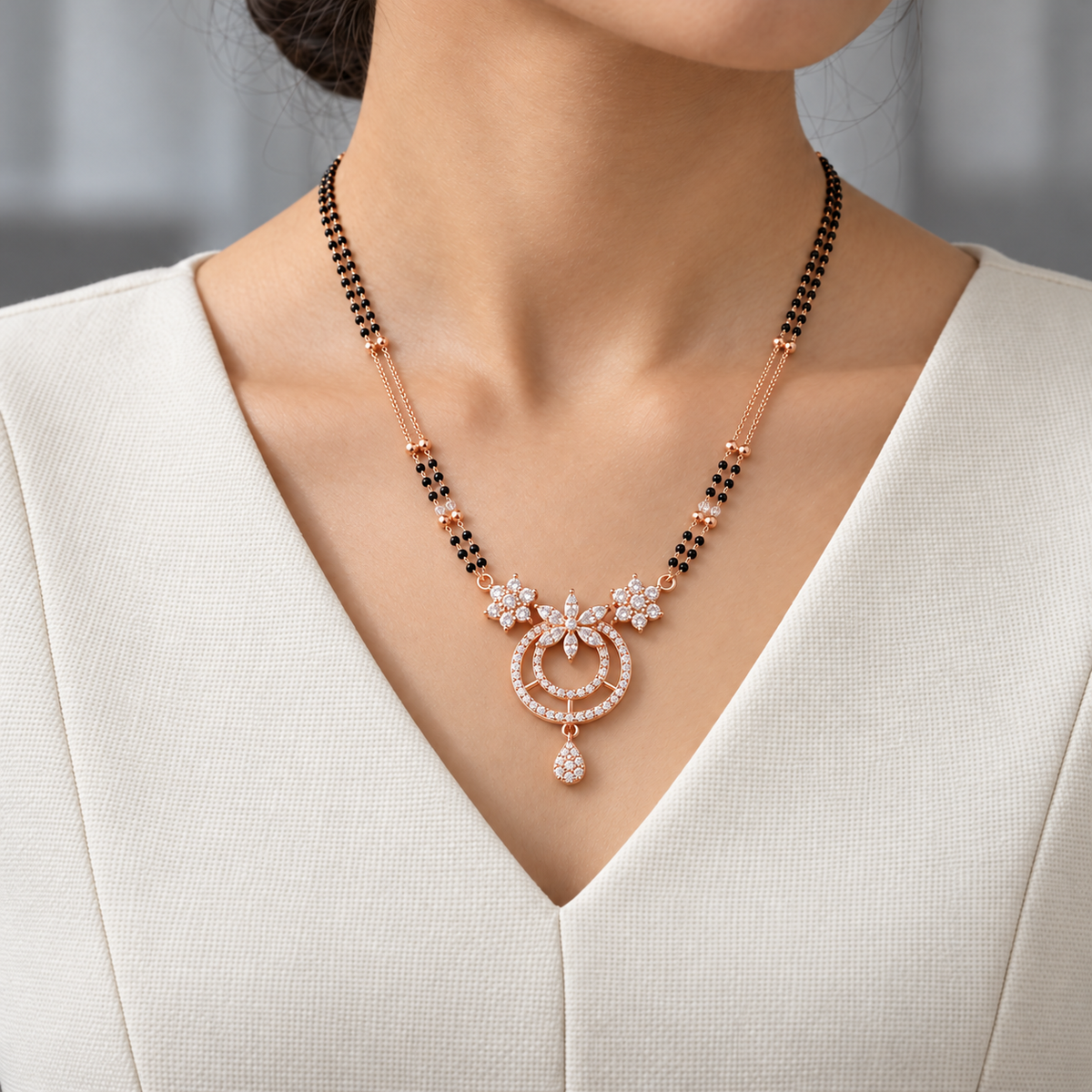 Noelle Mangalsutra worn with an ivory woven V-neck dress, showing the pendant and black bead chain.