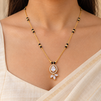 Pallavi Mangalsutra worn with an ivory saree, showing its teardrop halo and three marquise accents