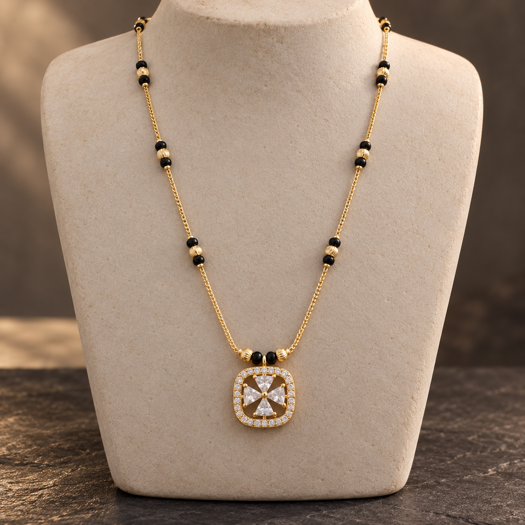 Front view of Rajshree Mangalsutra with a rounded-square openwork pendant on an ivory stone display