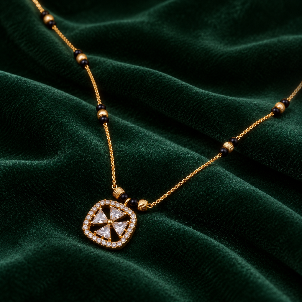 Oblique view of Rajshree Mangalsutra on deep emerald velvet, showing its four clear pinwheel accents