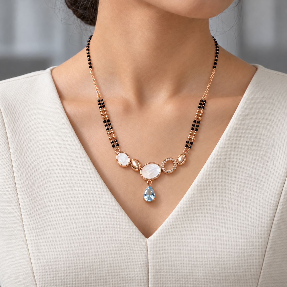 Renelle Mangalsutra worn with an ivory woven V-neck dress, showing the pendant and black bead chain.