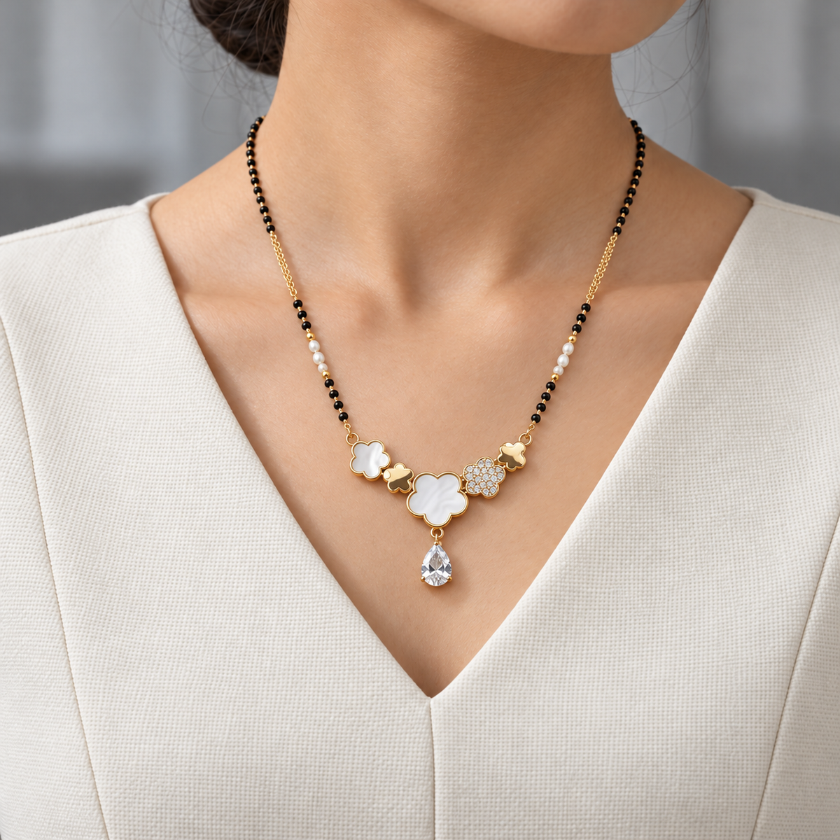 Verelle Mangalsutra worn with an ivory woven V-neck dress, showing the pendant and black bead chain.