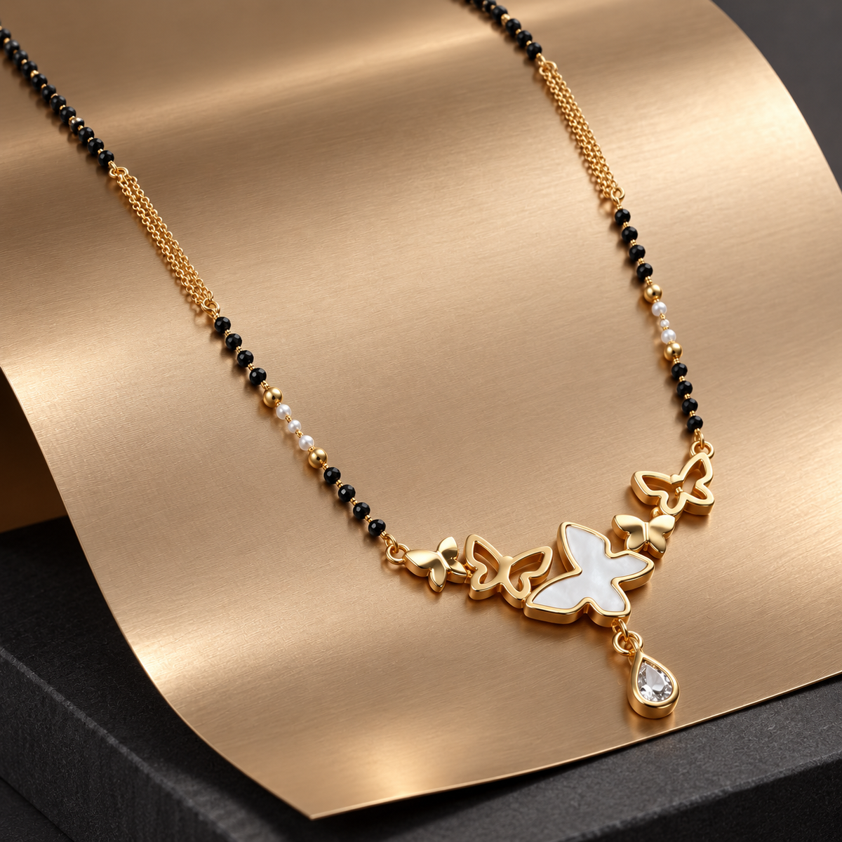 Vespera single-strand butterfly mangalsutra on brushed champagne metal.
